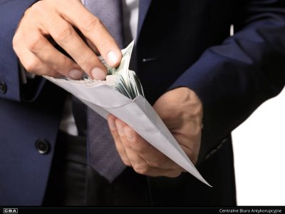 zbliżenie na osobę trzymającą otwartą kopertę z plikiem banknotów
