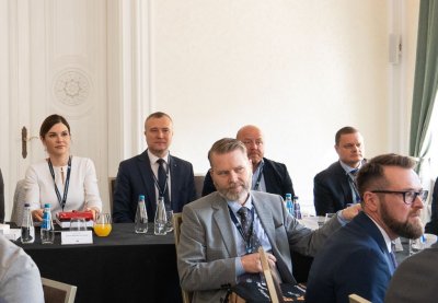 Kilka osób siedzących przy stole konferencyjnym.