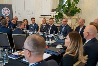 Kilka osób siedzących przy stole konferencyjnym.