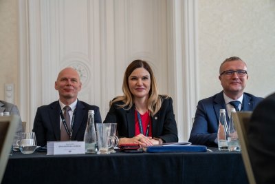 trzy osoby siedzące przy stole konferencyjnym.