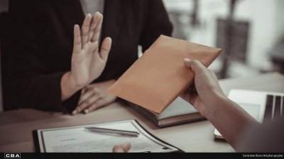 Zbliżenie na dłoń trzymającą kopertę, druga dłoń podniesiona ku górze.