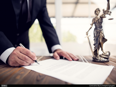 Podpisanie dokumentów, w tle waga sędziowska