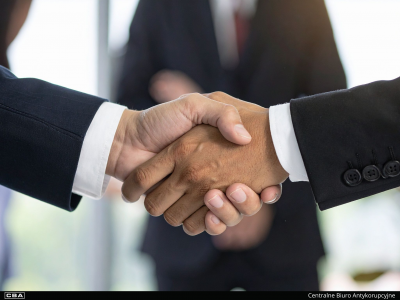 Dwóch mężczyzn wymienia uścisk ręki.