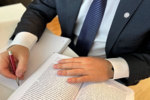 person sitting at desk, close-up of lying documents