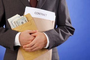 A person holding documents and an envelope with banknotes
