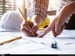 Two people collaborating over architectural blueprints.