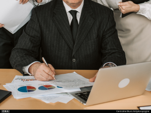 A man sitting at a desk, with documents on it.