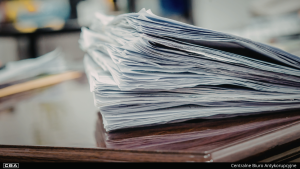A pile of documents on the table.