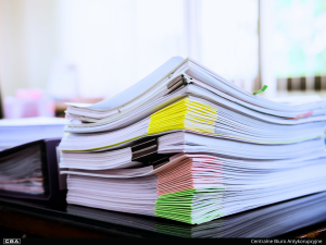 A pile of documents on the desk.